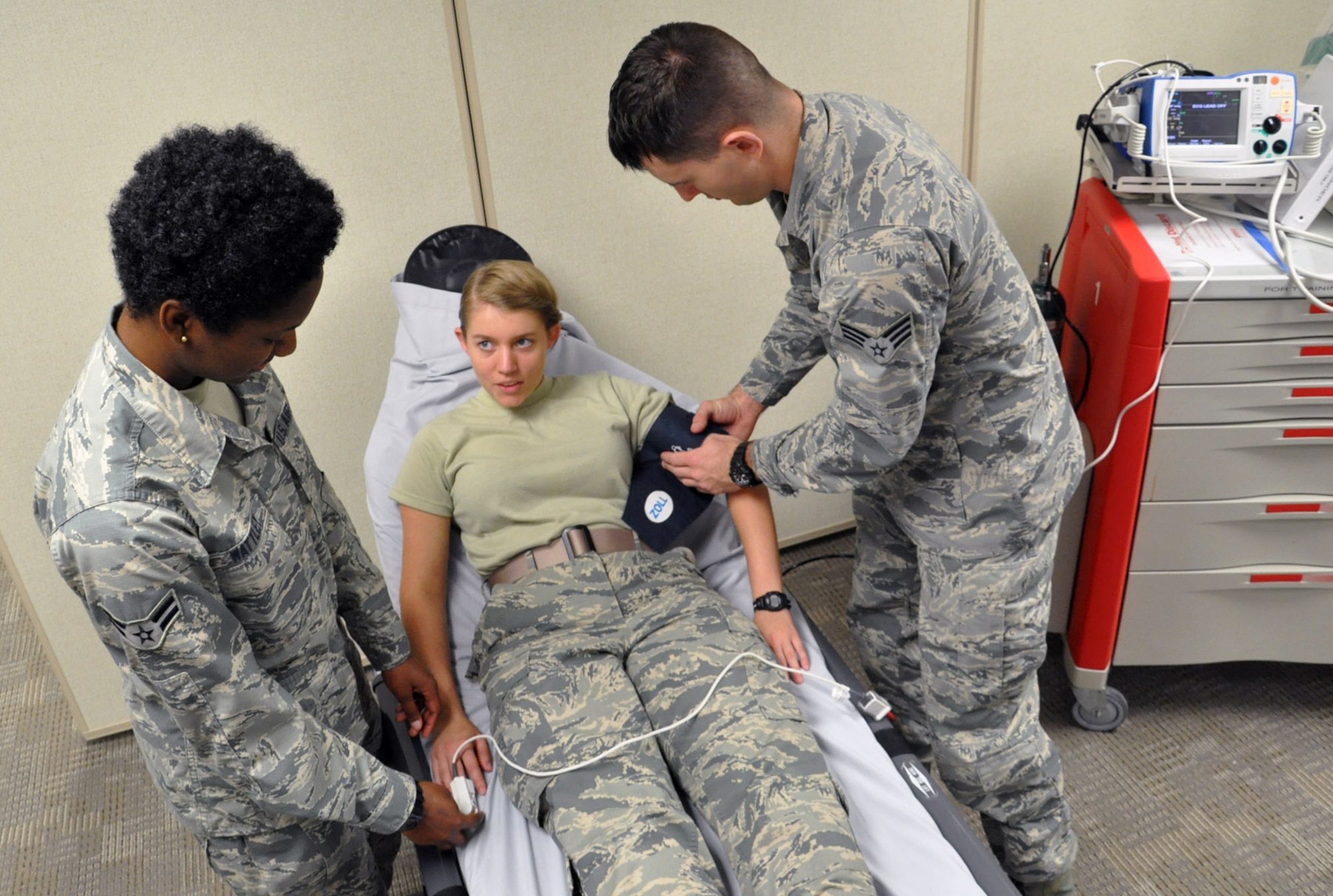 Airman 1st Class Brooke Summy fills the role of a patient while Senior Airman John Tice places a blood pressure cuff on her left arm and Airman 1st Class Janeisha Wattley places a pulse oximeter on her right hand. All three Airmen are currently AMSA Phase II students. (U.S. Air Force photo/Bryan Ripple)

