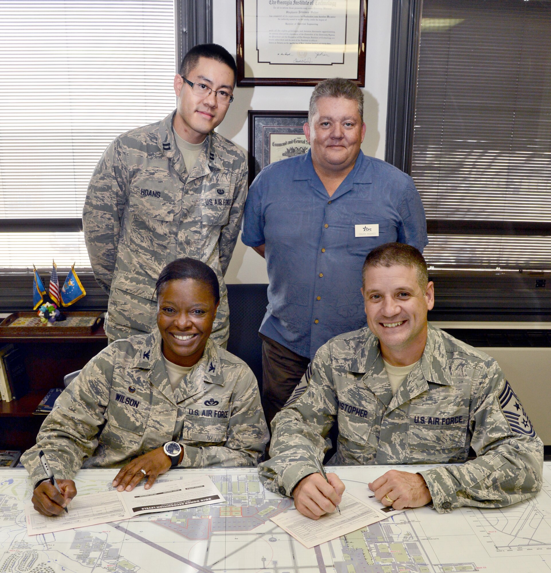 Col. Stephanie Wilson, 72nd Air Base Wing commander, and 72nd ABW Command Chief Thomas Christopher sign their 2015 Combined Federal Campaign pledge cards. With them are Tinker’s CFC project officer Capt. Joseph Hoang, left, and Chuck Hughes, a CFC loaned executive. Tinker’s other LE’s are LaRee Anderson and Airman 1st Class Sara Rivera. The campaign kicks off today and runs through Nov. 22. (Air Force photo by Kelly White/Released)