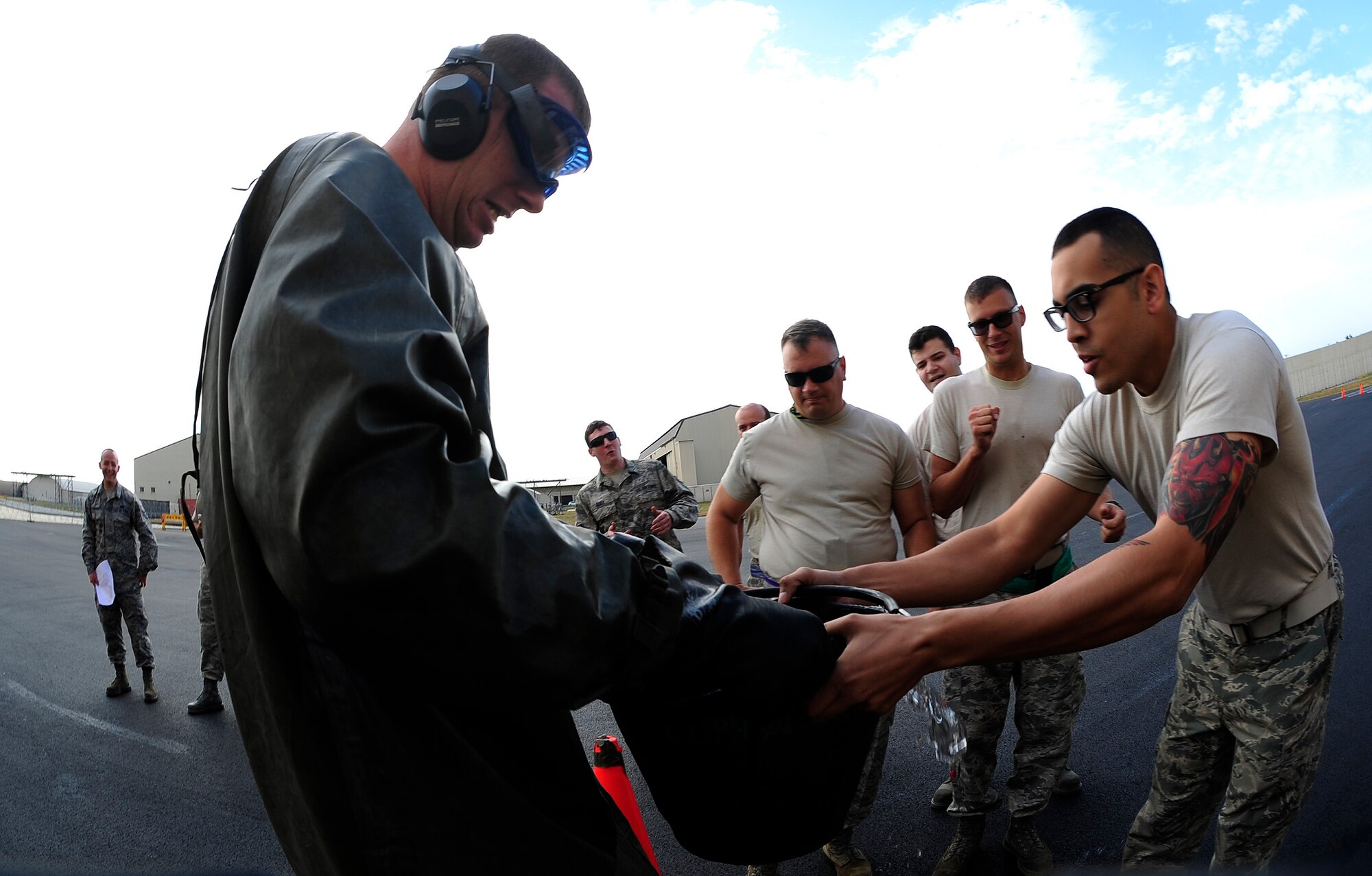 Airmen from the 8th Maintenance Squadron fabrication flight participate in a personal protective equipment relay during an 8th Maintenance Group Safety Olympics event at Kunsan Air Base, Republic of Korea, Sept. 30, 2015. The purpose of the event was to highlight the importance of workplace safety while simultaneously drawing camaraderie among all Airmen in the 8th MXG. (U.S. Air Force photo by Staff Sgt. Nick Wilson/Released)