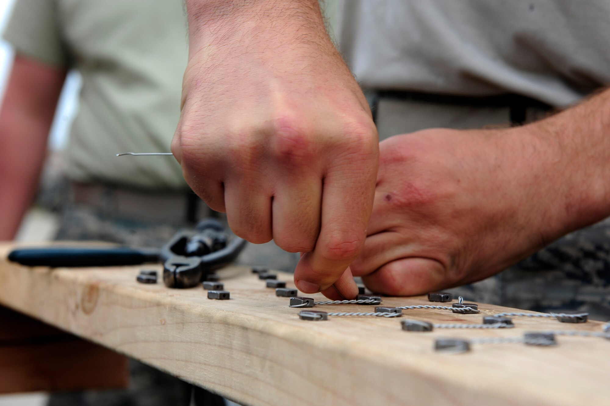 An Airman participates in a safety wire challenge during an 8th Maintenance Group Safety Olympics event at Kunsan Air Base, Republic of Korea, Sept. 30, 2015. The purpose of the event was to highlight the importance of workplace safety while simultaneously drawing camaraderie among all Airmen in the 8th MXG. (U.S. Air Force photo by Staff Sgt. Nick Wilson/Released)