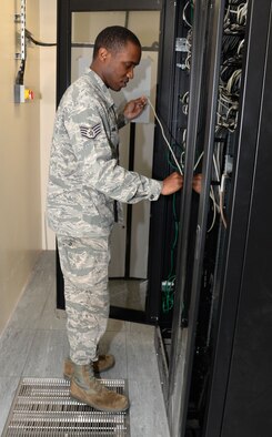 U.S. Air Force Staff Sgt. Christerfer James, 100th Communication Squadron Cyber Transport supervisor, opens a communication cabinet prior to patching ports Sept. 4, 2015, on RAF Mildenhall, England. James was performing cable management for voiceover internet protocol and computer-port activation. (U.S. Air Force photo by Gina Randall/Released)