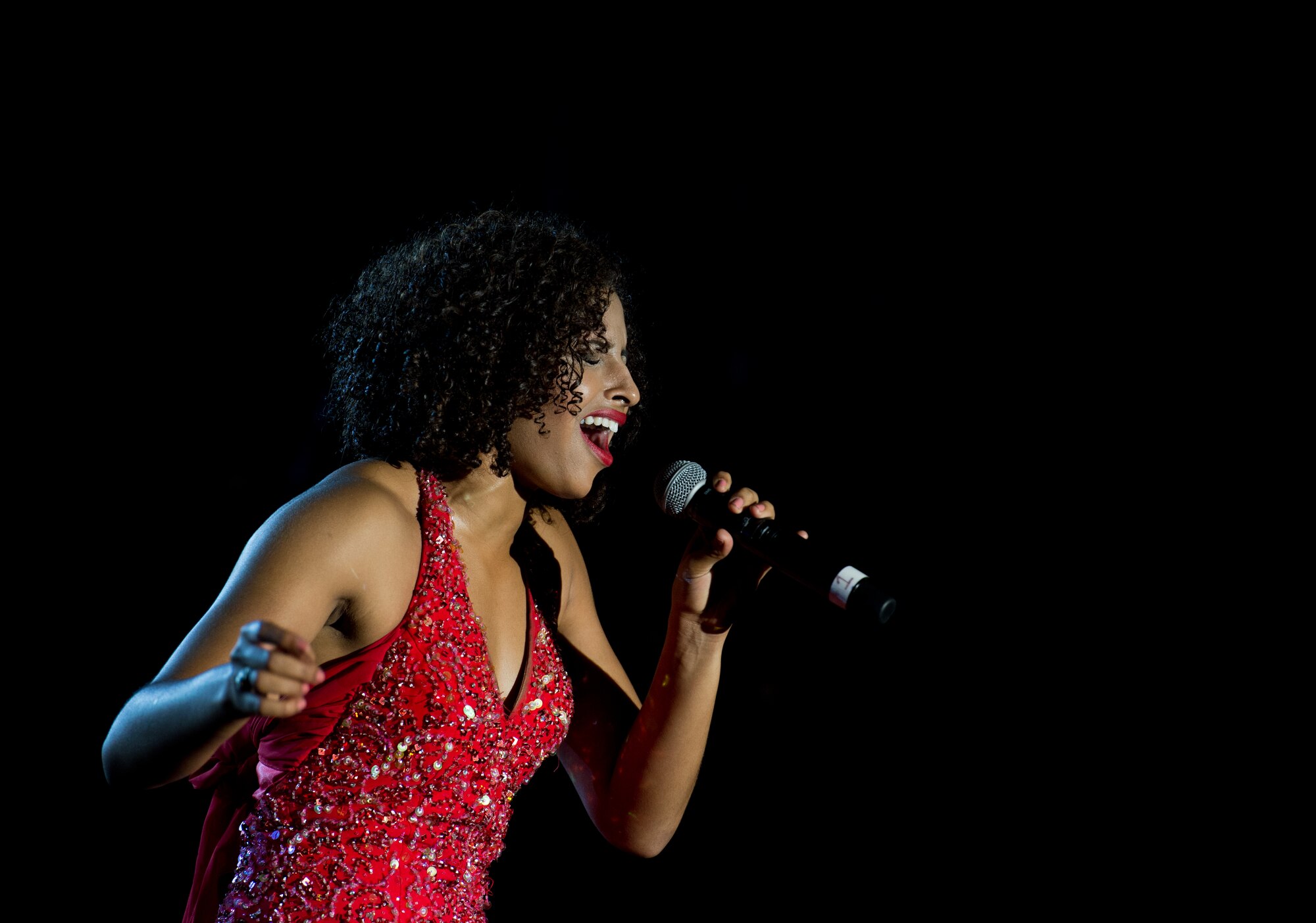 Second Lt. Nicque Robinson, 319th Contracting Flight contracting specialist, sings during a Tops in Blue performance Sept. 27, 2015, at Ramstein Air Base, Germany. During each annual tour, Tops in Blue entertains more than 250,000 military personnel and their families, presenting an average of 120 performances at 100 locations worldwide. The showcase is presented throughout the continental United States, Canada, Europe, Central America, Alaska and the Pacific. (U.S. Air Force photo/ Senior Airman Jonathan Stefanko)