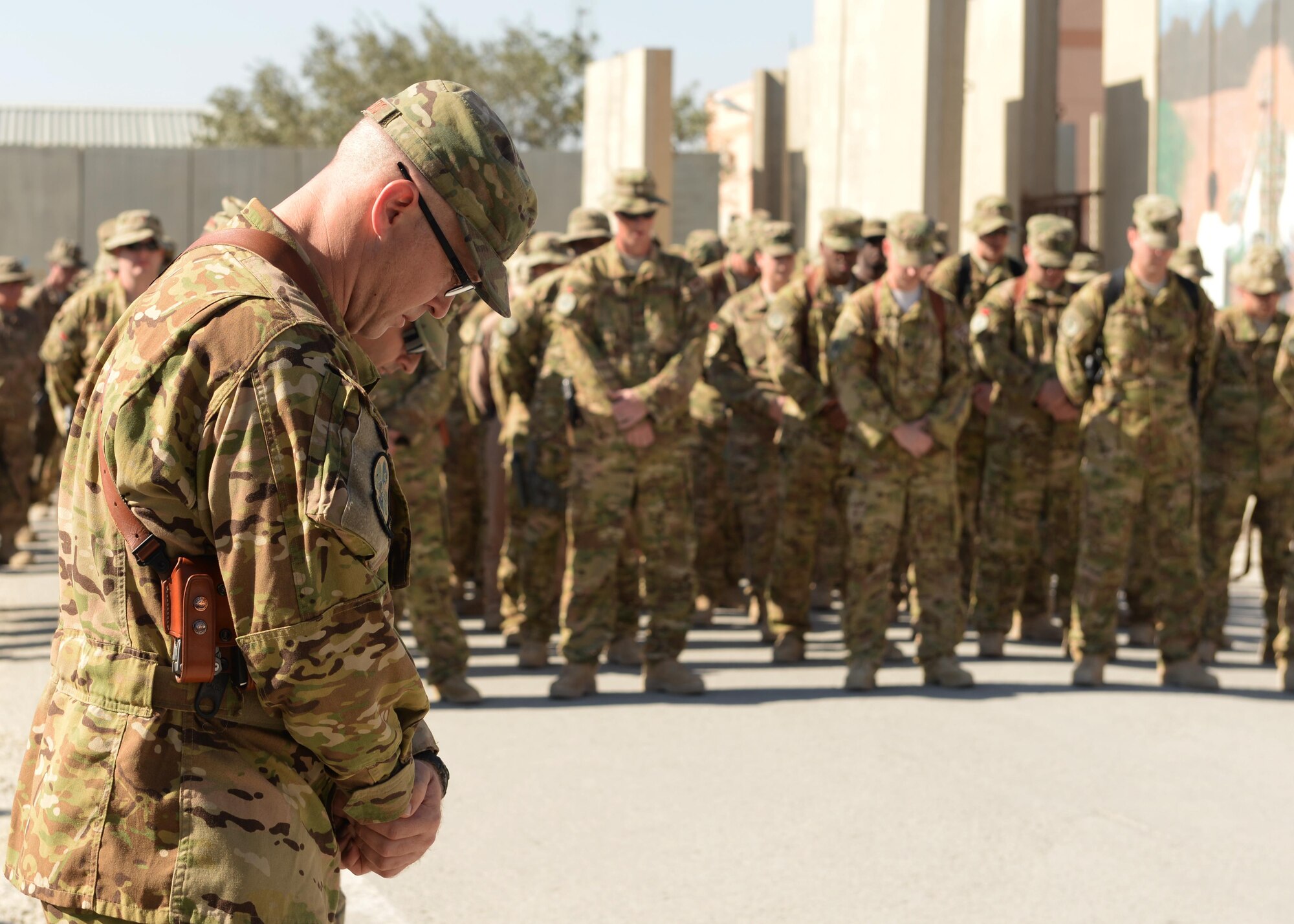 U.S. Air Force Lt. Col. Mitchell Spillers, 774th Expeditionary Airlift Squadron commander, bows his head during a moment of silence during a fallen comrade memorial ceremony held in honor of six Airmen Oct. 3, 2015, at Bagram Airfield, Afghanistan. The six Airmen, four who were pilots and crew members, Capts. Jordan Pierson and Jonathan Golden, Staff Sgt. Ryan Hammond and Senior Airman Quinn Johnson-Harris, and two who were security forces fly away security team members, Airman 1st Class Kcey Ruiz and Senior Airman Nathan Sartain, lost their lives when their C-130J crashed shortly after take-off from Jalalabad Airfield in Afghanistan, Oct. 2, 2015. (U.S. Air Force photo by Senior Airman Cierra Presentado/Released)