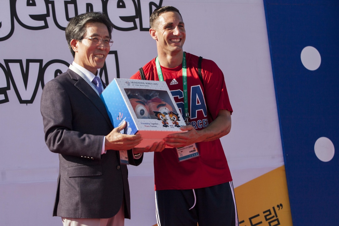 United States Men’s Soccer player Sgt Christopher Krueger accepts a gift from the Mayor during the 2015 6th CISM World Games, Athlete Village Opening Ceremony. The CISM World Games provides the opportunity for the athletes of over 100 different Nations to come together and enjoy friendship through sport. The sixth annual CISM World Games are being held aboatd Mungyeong, South Korea., Sept. 30 -Oct. 11.  (Photo by Sgt. Ashley N. Cano)