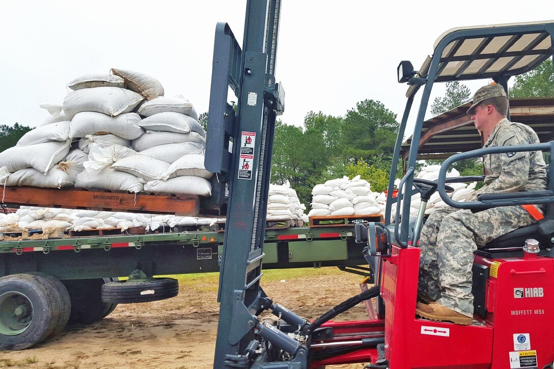 U.S. Army Spc. Joshua Monk helps move and deliver sandbags to county emergency managers during flood response in Chesterfield, S.C., Oct. 3, 2015. Monk is a forklift operator with the 1052nd Transportation Company, South Carolina National Guard. State officials projected historic amounts of rainfall for the region after a weather system collided with the outer bands of Hurricane Joaquin off the coast. South Carolina National Guard photo by Sgt. David Erskine