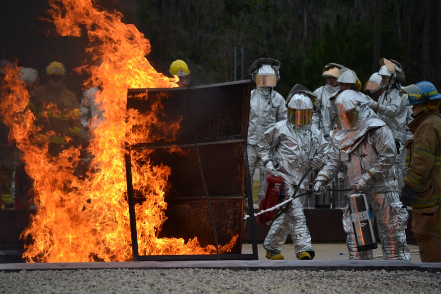 Firefighters from the 120th Airlift Wing work to extinguish a ground-fuel fire at the Fire Academy of the South. Thirty-eight members of the Montana Air National Guard deployed to Jacksonville, Fla., and integrated with the Florida Air National Guard for two weeks of specialty training in February 2015.  (U.S. Air National Guard photo/Master Sgt. Anthony Barille)