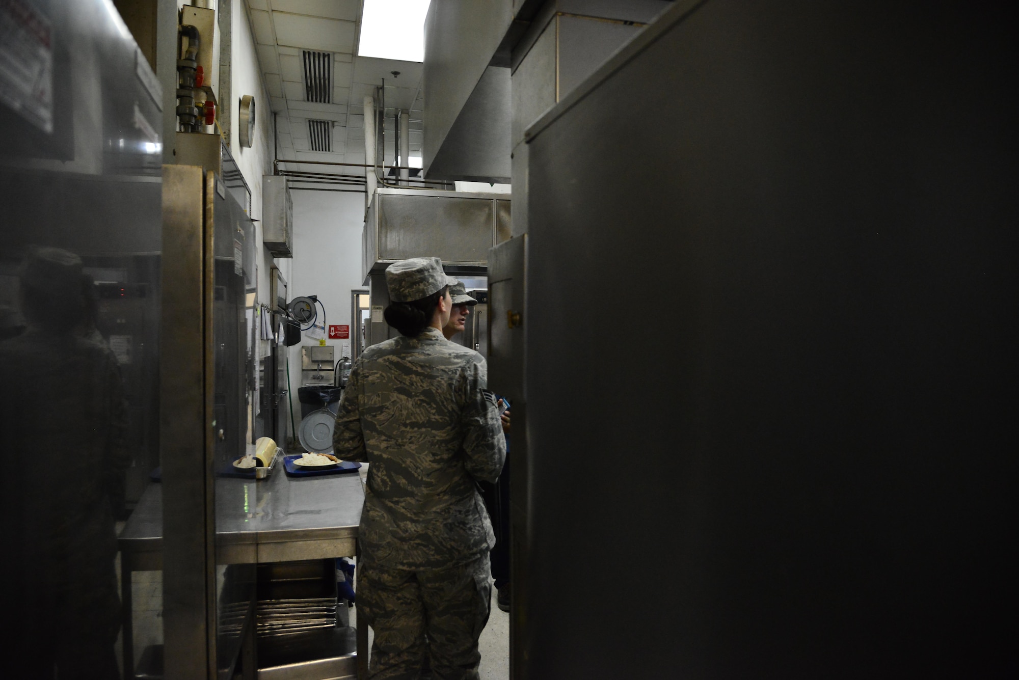 Senior Airman Leah Smith, 379th Expeditionary Medical Operations Support Squadron Bioenvironmental, walks through the kitchen of a dining facility inspecting the ventilation systems September 30, 2015 at Al Udeid Air Base, Qatar. (U.S. Air Force photo/Staff Sgt. Alexandre Montes)  