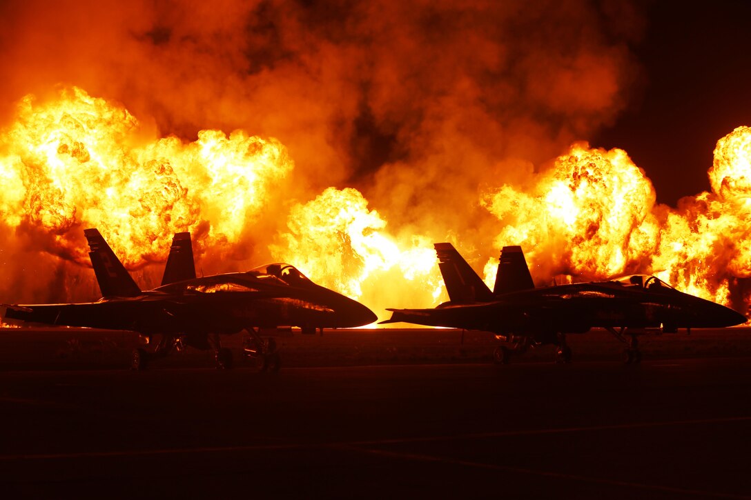 The Wall of Fire erupts behind the Blue Angels static display during the 2015 MCAS Miramar Air Show aboard Marine Corps Air Station Miramar, California, Oct. 3. The Wall of Fire was the final performance for the Twilight Show during the air show. (U.S. Marine Corps Photo by Sgt. Michele Hunt/Released)