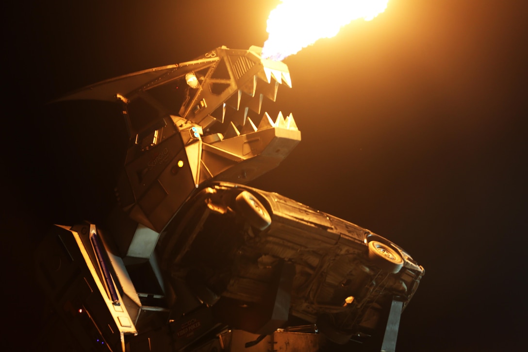 Robosaurus takes a bite out of an old rusty car during its performance at the 2015 MCAS Miramar Air Show aboard Marine Corps Air Station Miramar, California, Oct. 3. Robosaurus transforms from a semi-truck to a 30-ton, 40-foot tall metal T-Rex. (U.S. Marine Corps photo by Sgt. Michele Hunt/Released)