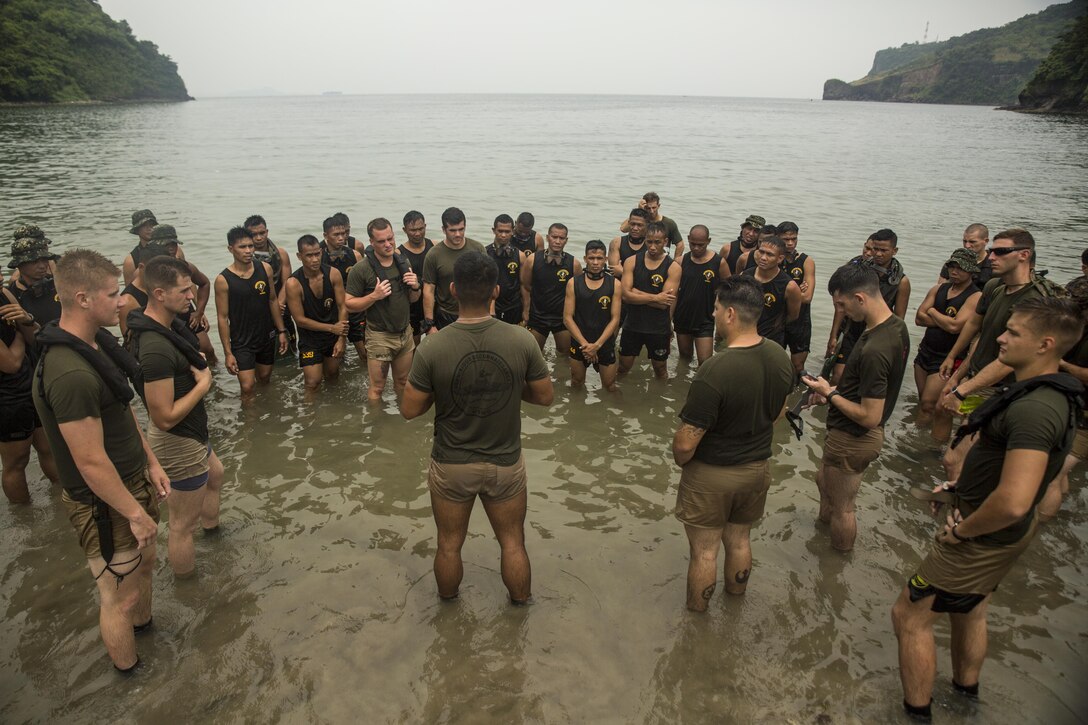 U.S. Marine Corps Sgt. Rafael De Hoyas, center, talks to Philippine and U.S. Marines about clandestine operations at Ternate, Philippines, Oct. 1, 2015. The Marines rehearsed clandestine landings with their Filipino counterparts, which increased their mission readiness during maritime raid operations. This training was in part of Amphibious Landing Exercise 2015, which is an annual, bilateral training exercise conducted by U.S. Marine and Navy Forces with the Armed Forces of the Philippines in order to strengthen our interoperability and working relationships across a wide range of military operations — from disaster relief, to complex expeditionary operations. De Hoyas from San Antonio, Texas, is a reconnaissance man with 3rd Reconnaissance Battalion, 3rd Marine Division, III Marine Expeditionary Force. The Philippine Marines are reconnaissance men with 64th Force Reconnaissance Company, Marine Special Operations Group.