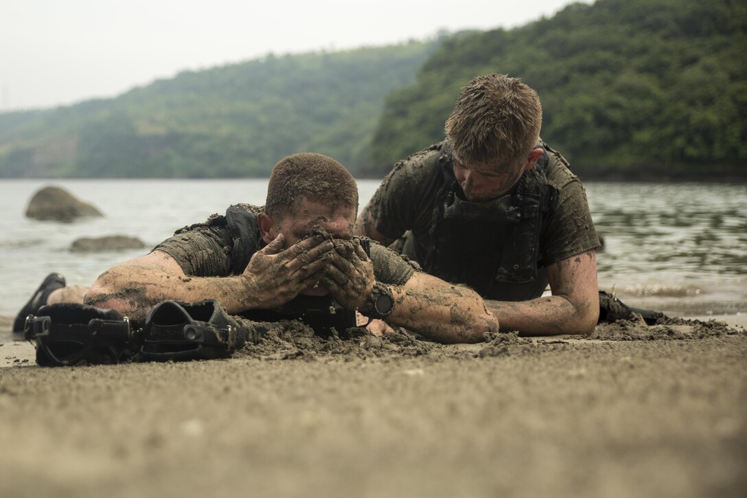 Sgt. John Portugal, left, and Lance Cpl. Tanner Hurst “sugar cookie” themselves during clandestine landing rehearsals at Ternate, Philippines, Oct. 1, 2015. The Marines rehearsed clandestine landings with their Filipino counterparts, which increased their mission readiness during maritime raid operations. During clandestine landings, scout swimmers swim to shore and use the “sugar cookie” method to prevent themselves from being detected by glare or shine from their body and equipment. This training is in part of  Amphibious Landing Exercise 2015, which is an annual, bilateral training exercise conducted by U.S. Marine and Navy Forces with the Armed Forces of the Philippines in order to strengthen our interoperability and working relationships across the range of military operations — from disaster relief, to complex expeditionary operations. Portugal from Vacaville, Calif., is a reconnaissance man with 3rd Reconnaissance Battalion, 3rd Marine Division, III Marine Expeditionary Force. Hurst from Simi Valley, Calif., is a reconnaissance man with, 3rd Recon Bn., 3rd MarDiv, III MEF.