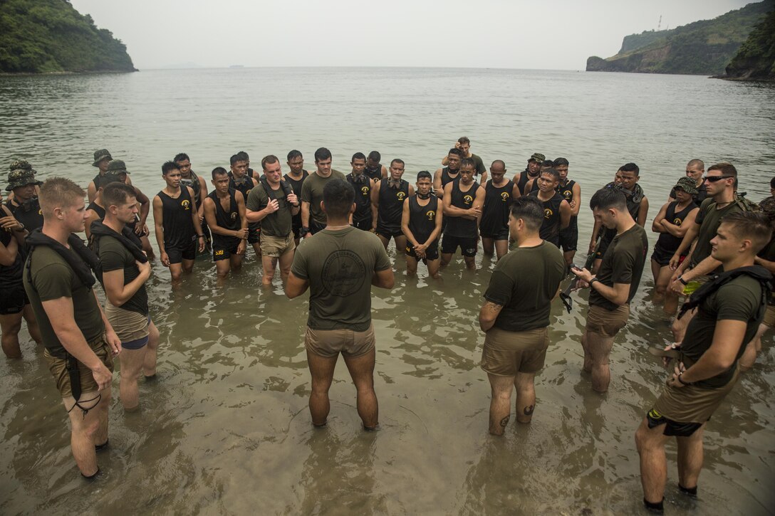 U.S. Marine Corps Sgt. Rafael De Hoyas, center, talks to Philippine and U.S. Marines about clandestine operations at Ternate, Philippines, Oct. 1, 2015. The Marines rehearsed clandestine landings with their Filipino counterparts, which increased their mission readiness during maritime raid operations. This training was in part of Amphibious Landing Exercise 2015, which is an annual, bilateral training exercise conducted by U.S. Marine and Navy Forces with the Armed Forces of the Philippines in order to strengthen our interoperability and working relationships across a wide range of military operations — from disaster relief, to complex expeditionary operations. De Hoyas from San Antonio, Texas, is a reconnaissance man with 3rd Reconnaissance Battalion, 3rd Marine Division, III Marine Expeditionary Force. The Philippine Marines are reconnaissance men with 64th Force Reconnaissance Company, Marine Special Operations Group.