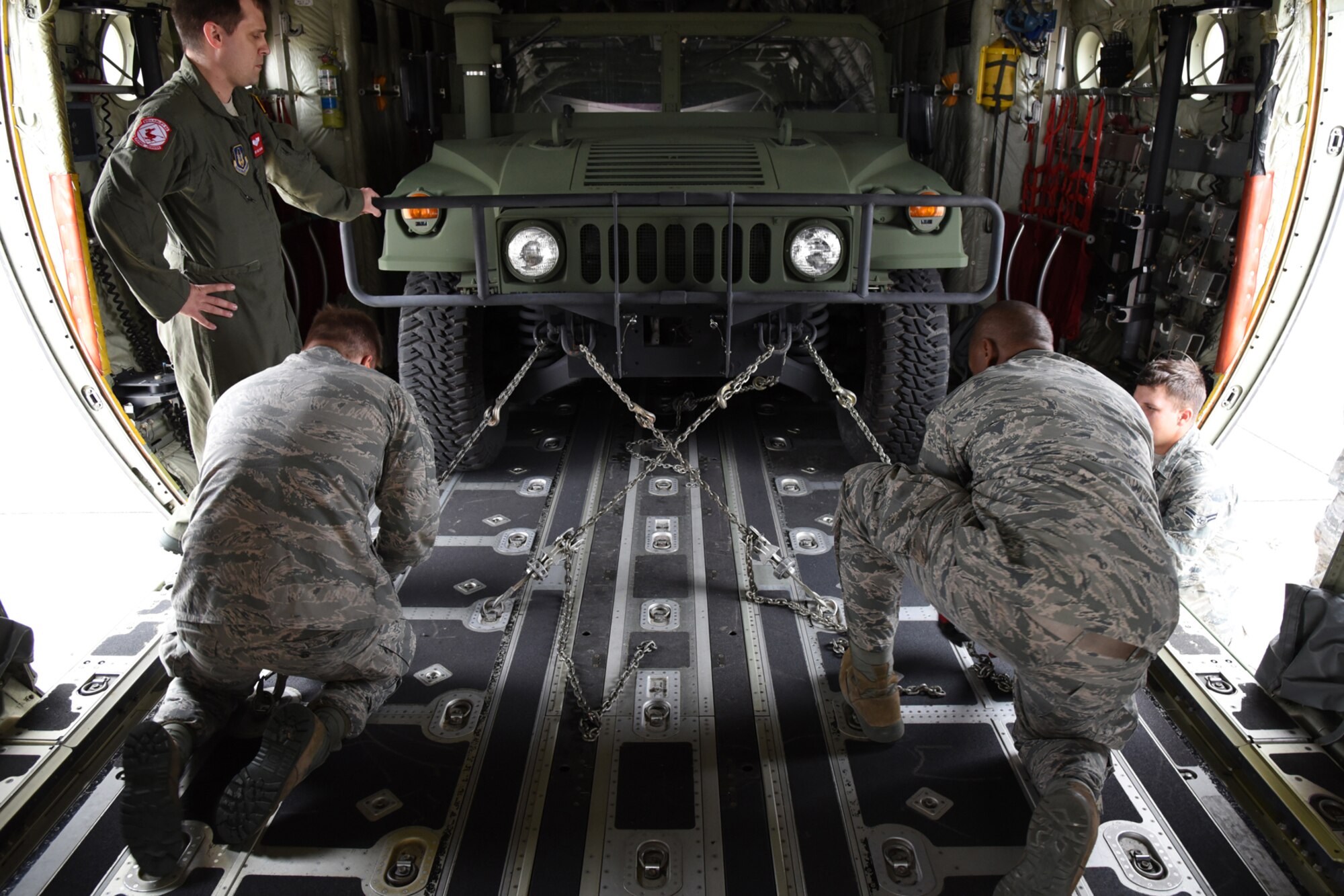 Members of the 403rd Aerial Port Squadron secure a Humvee to the floor of the cargo compartment of a C-130J during the “chains and devices tie down” event of the “Port Dawg” Challenge Oct. 3, 2015, at Keesler Air Force Base, Mississippi. The competition is designed to develop healthy competitiveness and esprit de corps while working on building a more proficient aerial port squadron. (U.S. Air Force photo/Tech. Sgt. Ryan Labadens)
