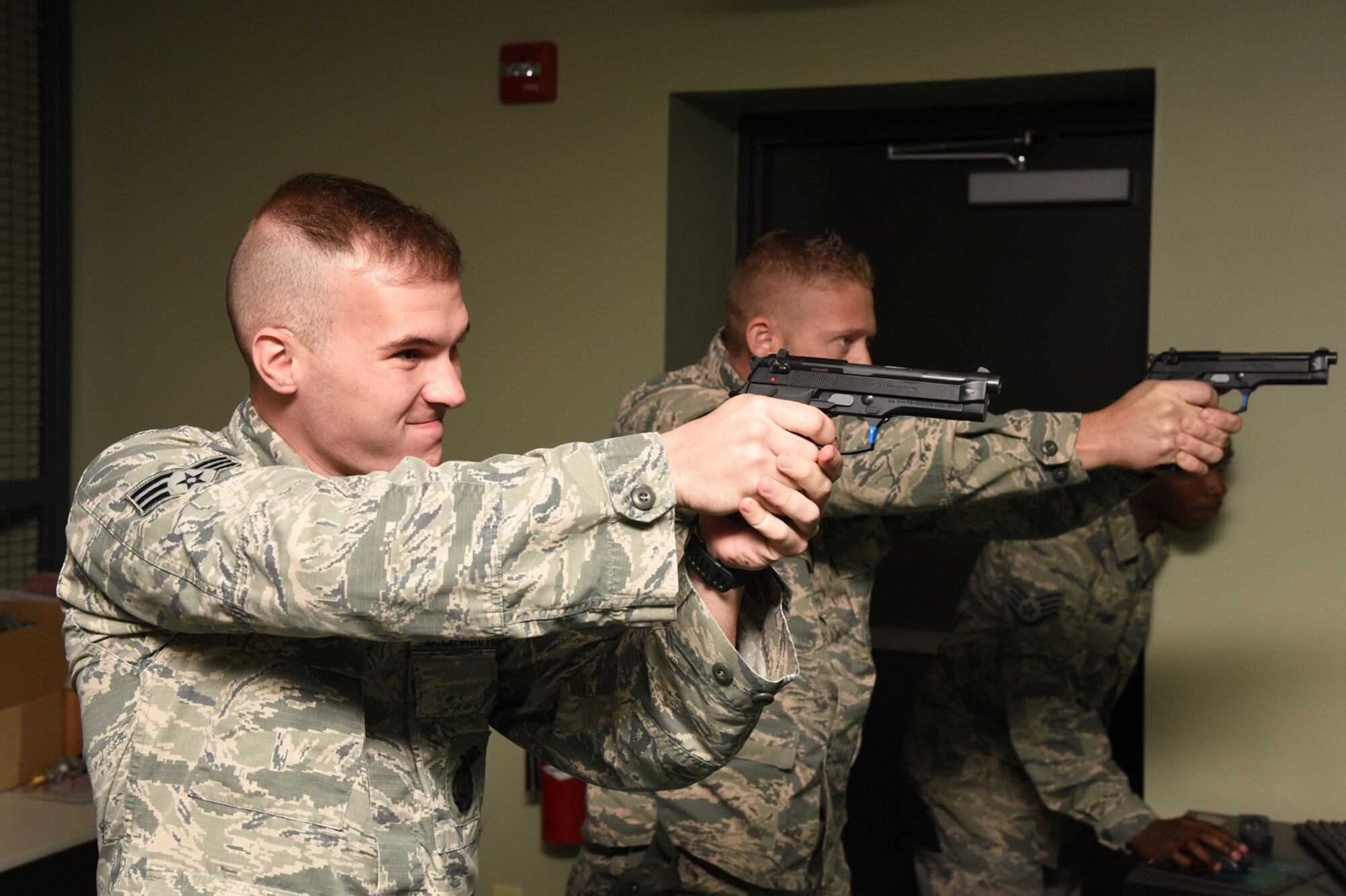 Staff Sgt. Christopher Cabibi (right) and Senior Airman Brandon Chesterman, 403rd Security Forces Squadron fire team members, train on the latest version of the Firearms Training System at Keesler Air Force Base, Mississippi, Oct. 4, 2015. The system provides multiple, realistic scenarios for which security forces members can receive instant feedback based on their training performance. (U.S. Air Force photo/Tech. Sgt. Ryan Labadens)
