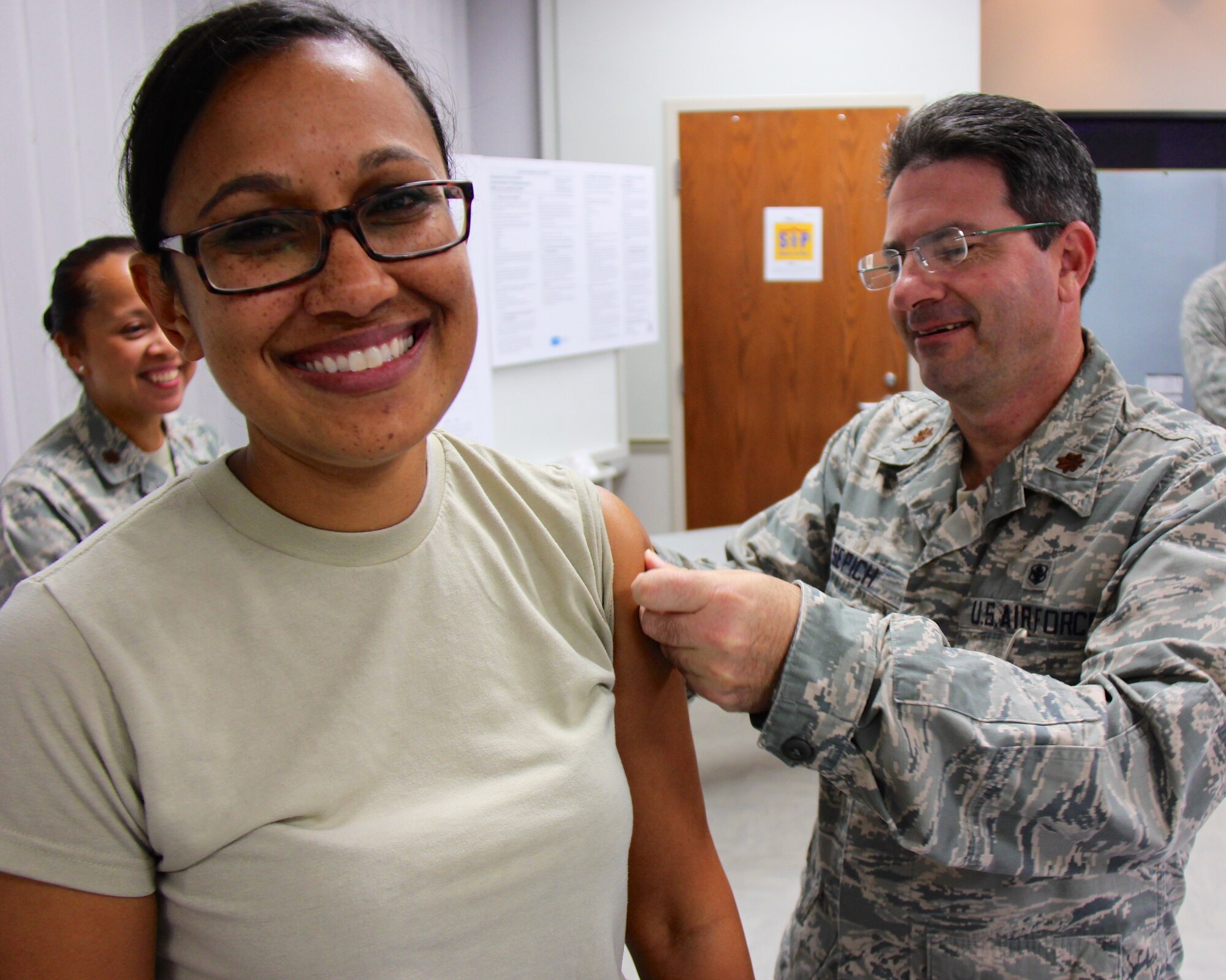 Maj. Jennifer Goetz receives her annual flu shot at the 932nd Airlift Wing from Maj. Michael Sepich in the 932nd Medical Group building.  Shots were given frequently during the morning on Saturday of the Unit Training Assembly.  (U.S. Air Force photo by Maj. Stan Paregien)