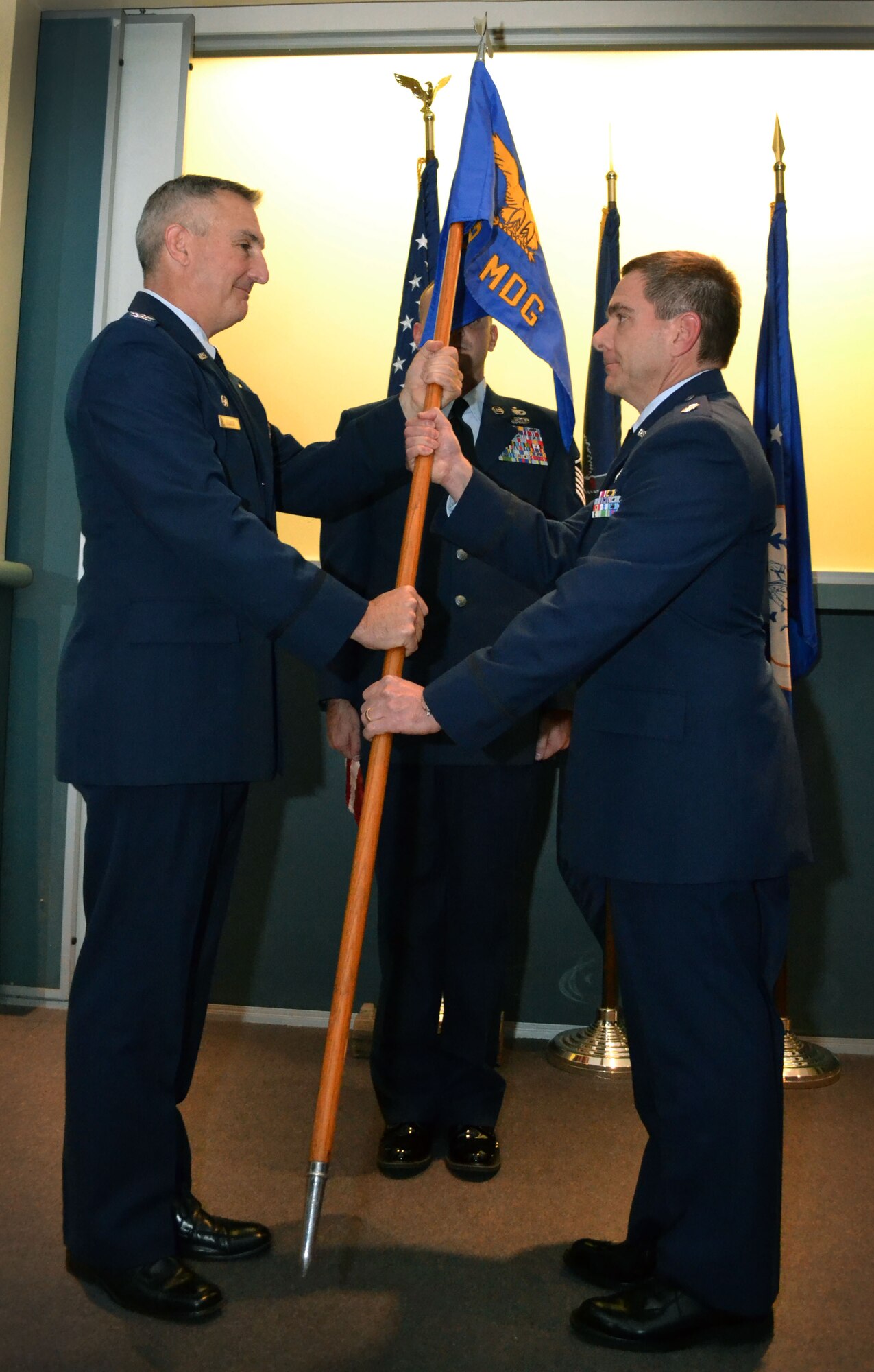 Col. Howard Eissler, 111th Attack Wing commander, hands the medical group’s flag to newly-appointed 111th Medical Group Commander Lt. Col. Scott Coradi Oct. 3, 1025, Horsham Air Guard Station, Pennsylvania. Lt. Col. John p. Quinn Jr., the outgoing commander, served in the position since 2009. (U.S. Air National Guard photo by Tech. Sgt. Andria Allmond/Released)