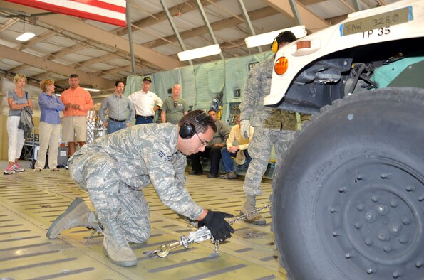 Senior Airman Ian Pro of the 26th Aerial Port Squadron secures a Humvee to a platform as part of an aerial port demonstration for 433rd Airlift Wing Honorary Commanders Oct. 3, 2015 at Joint Base San Antonio-Lackland. Honorary commanders received an up close look at a variety of specialties within the 433rd Mission Support Group during a tour that included logistics, security forces, fire department and explosive ordnance.   (U.S. Air Force photo/Tech. Sgt. Lindsey Maurice)