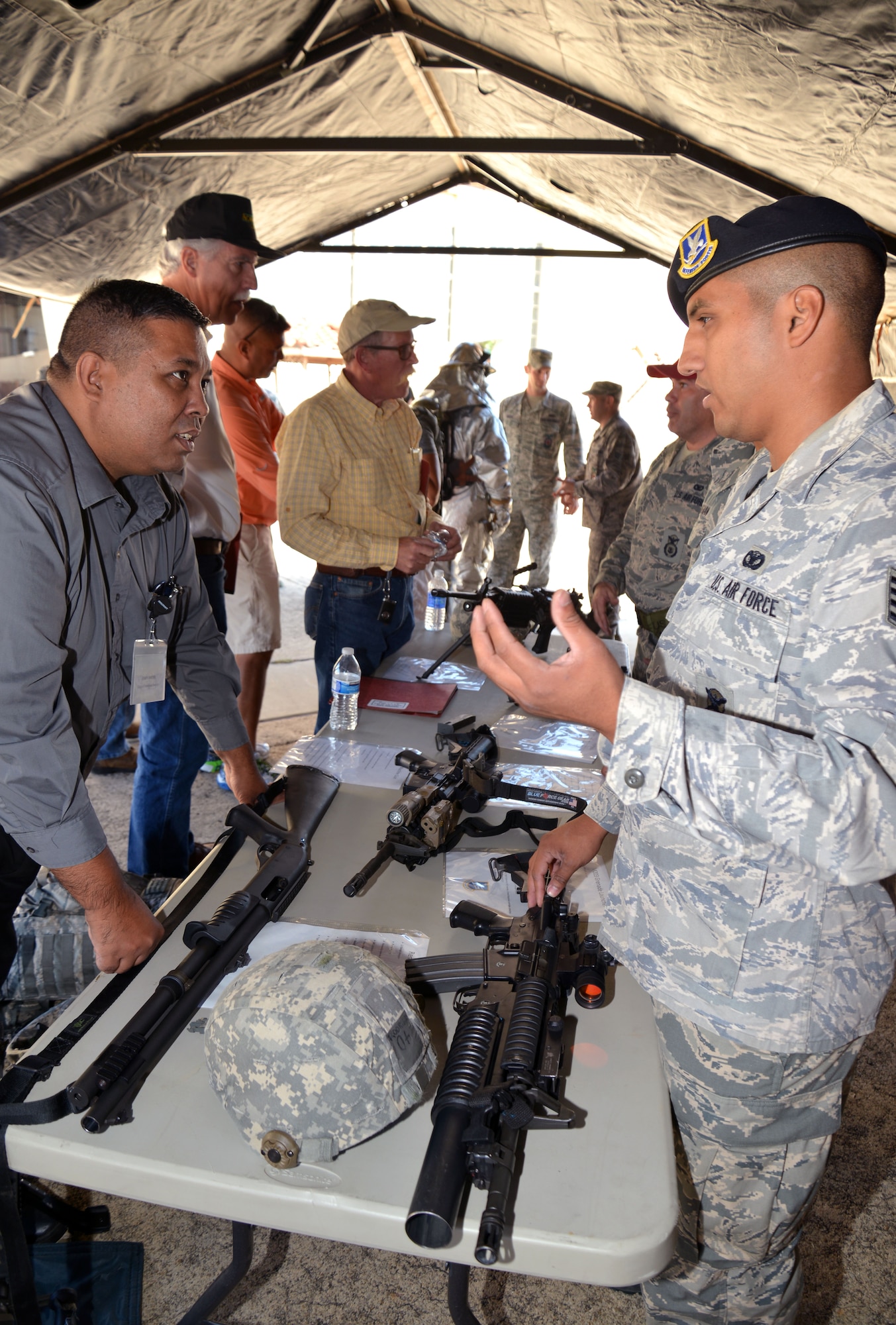 Staff Sgt. Gabriel Saucedo of the 433rd Security Forces Squadron discusses some of the weapons used by security forces Airmen with 433rd Airlift Wing Honorary Commander John Smith during a base tour Oct. 3, 2015 at Joint Air Base San Antonio-Lackland. Smith, who works for the Department of Homeland Security, and other local civic leaders were able to handle and try on a variety of equipment used by firefighters, security forces and explosive ordnance disposal teams within the wing during the tour. (U.S. Air Force photo/Tech. Sgt. Lindsey Maurice)