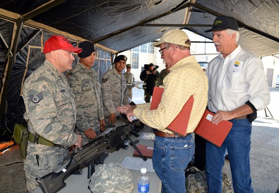 Staff Sgt. David Morino (left) of the 433rd Security Forces Squadron discusses some of the weapons used by security forces Airmen with 433rd Airlift Wing Honorary Commanders Steven Richmond (center) and Dave Saylor during a base tour Oct. 3, 2015 at Joint Air Base San Antonio-Lackland. The honorary commanders were able to handle and try on a variety of equipment used by firefighters, security forces and explosive ordnance disposal teams within the wing. Richmond is the president and director of maintenance at Pizza Hut of San Antonio and Saylor is the owner of Acadiana Café in San Antonio. (U.S. Air Force photo/Tech. Sgt. Lindsey Maurice)