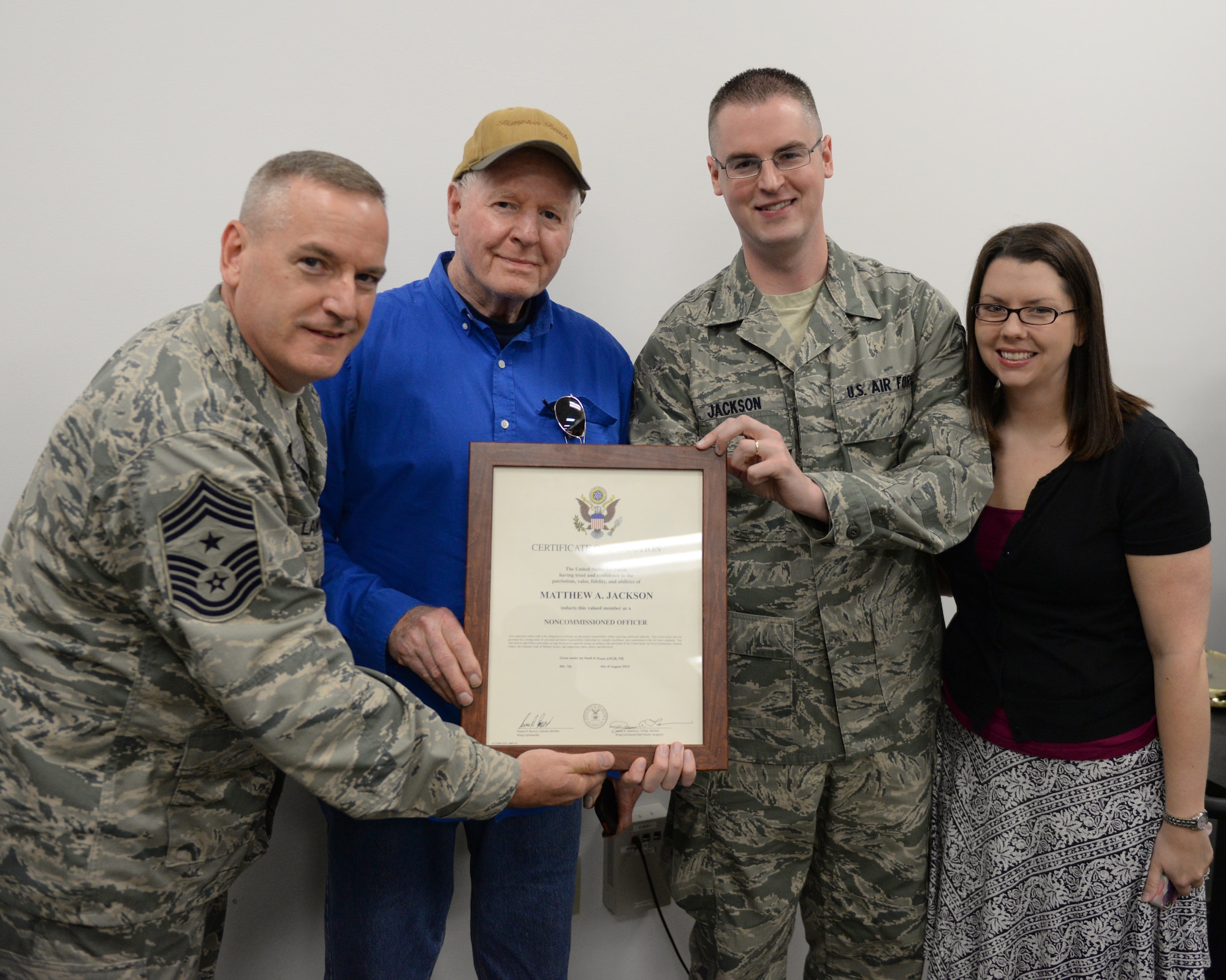 Staff Sgt. Matthew Jackson poses for a photo during his promotion with his father Robert Jackson, wife Deanna Jackson, and 157th Air Refueling Wing Command Chief Master Sgt. Jamie Lawrence Pease Air National Guard Base, N.H., Sept. 12, 2015.  Jackson recently completed the United States Strategic Command’s 12 day Joint Nuclear Command and Control course at Offutt, Air Force Base, Nebraska, where he graduated as a distinguished graduate. (U.S. Air National Guard photo by Staff Sgt. Curtis J. Lenz) 