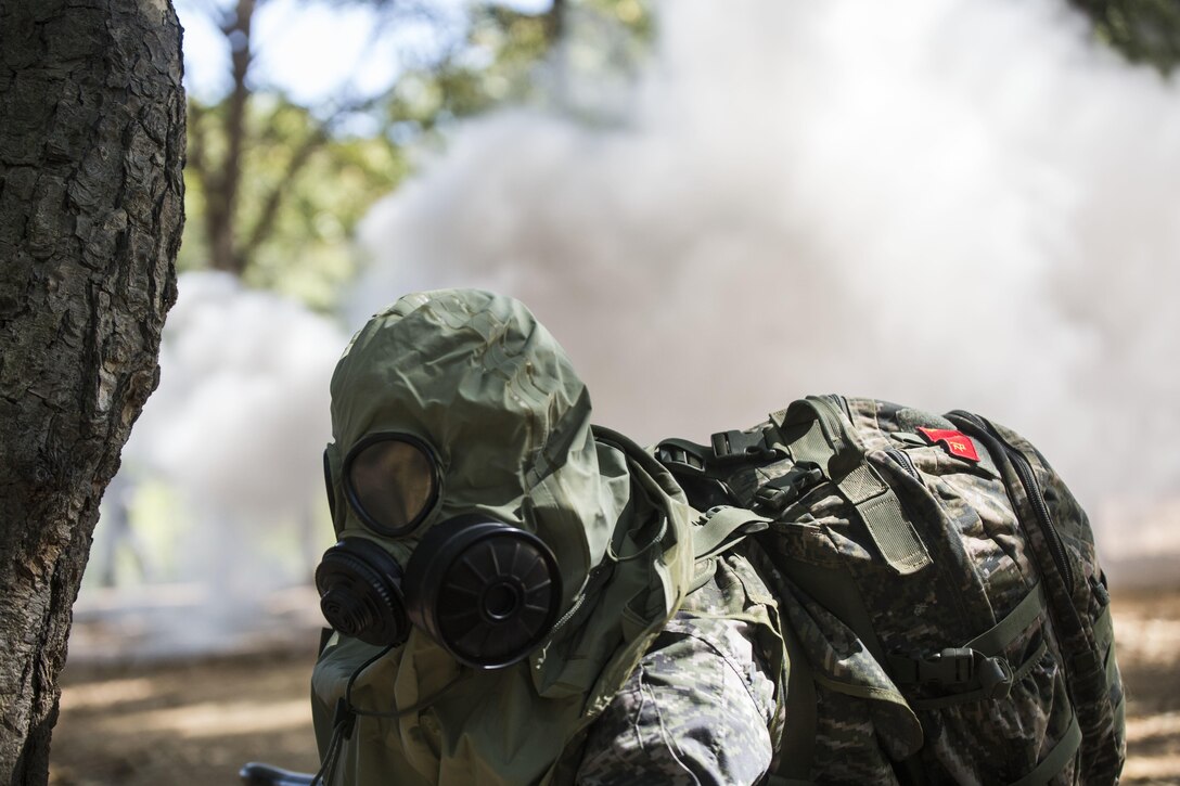 Republic of Korea Marine Lance Cpl. Jun Shin puts on his gas mask during a gas attack scenario as part of Korea Marine Exchange Program 15-12 at Gunha-Rhi, Republic of Korea, Sept. 17, 2015. The U.S. and ROK Marines practiced quickly putting on their gas mask and carrying the wounded to safety. KMEP 15-12 is an exercise in a series of continuous bilateral training exercises that enhance the ROK and U.S. alliance, promote stability on the Korean Peninsula and strengthen ROK and U.S. military capabilities and interoperability. Shin, from Ulsan, ROK, is with 2nd Company, 11th Battalion, 1st Regiment, 2nd Marine Division, ROK Headquarters Marine Corps.