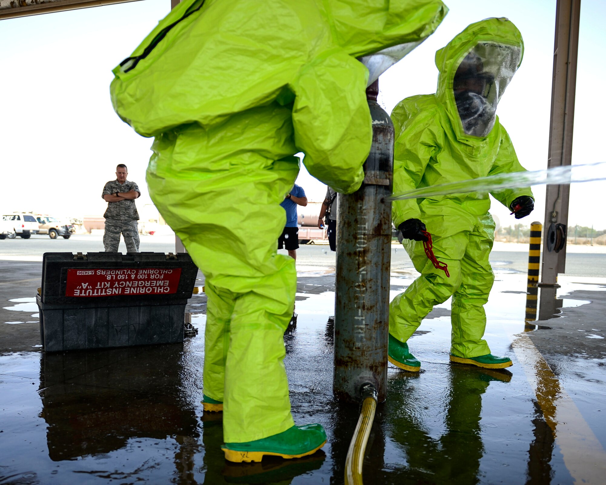 Members of the 386th Civil Engineer Squadron fire department assess a simulated chlorine spill scene during hazardous material certification training at an undisclosed location in Southwest Asia, Sept. 26, 2015. The training took several weeks, using the crawl, walk and run teaching technique. (U.S. Air Force photo by Senior Airman Racheal E. Watson/Released) 