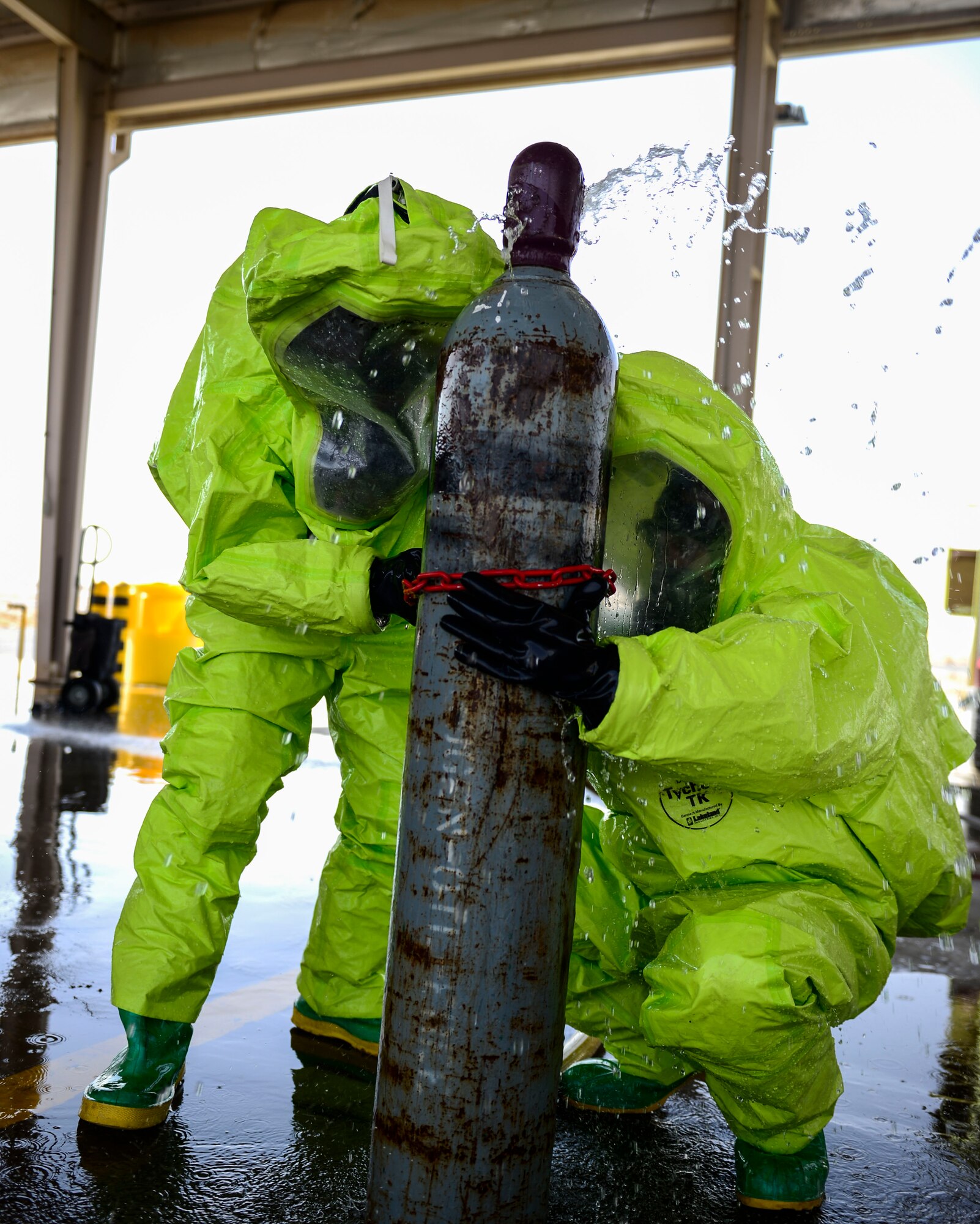 Firefighters of the 386th Civil Engineer Squadron use a clamp technique to stop simulated chlorine escaping a canister during hazardous material certification training at an undisclosed location in Southwest Asia, Sept. 26, 2015. Firefighters are certified annually on HAZMAT containment, which prepares members for possible scenarios in the elimination of global threats and the threat imposed in the Middle East. (U.S. Air Force photo by Senior Airman Racheal E. Watson/Released) 