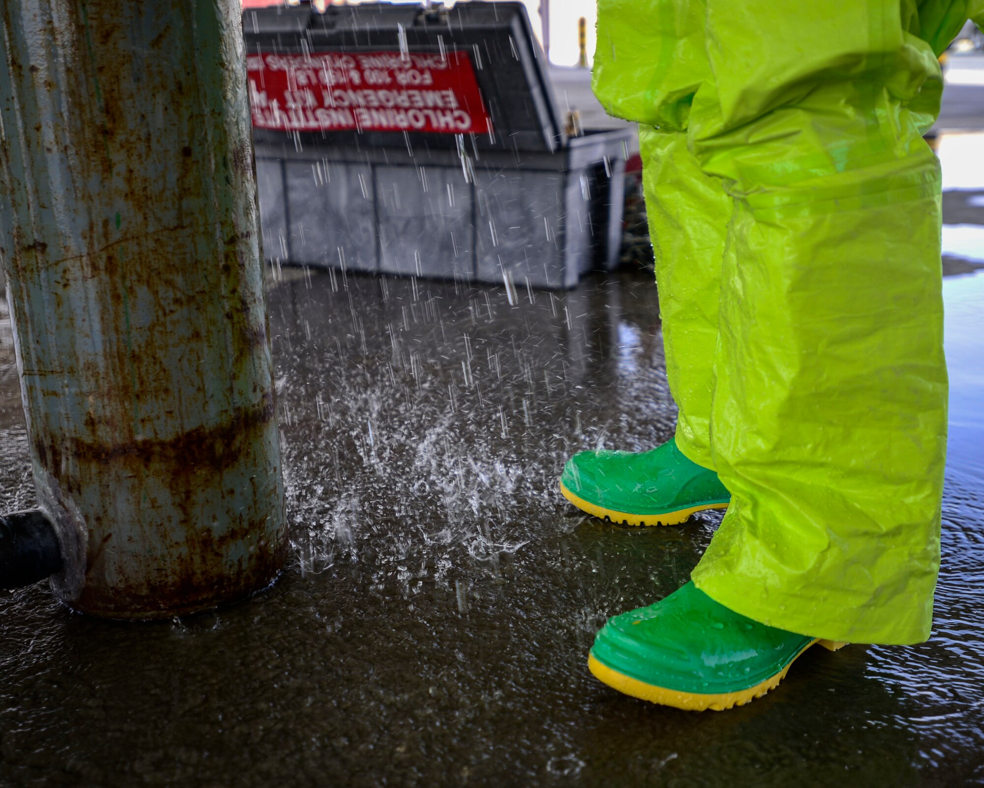 Simulated chlorine rains down during hazardous material certification training at an undisclosed location in Southwest Asia, Sept. 26, 2015. Firefighters support Operation Inherent Resolve with education in safety precaution procedures of containing hazardous material. (U.S. Air Force photo by Senior Airman Racheal E. Watson/Released) 