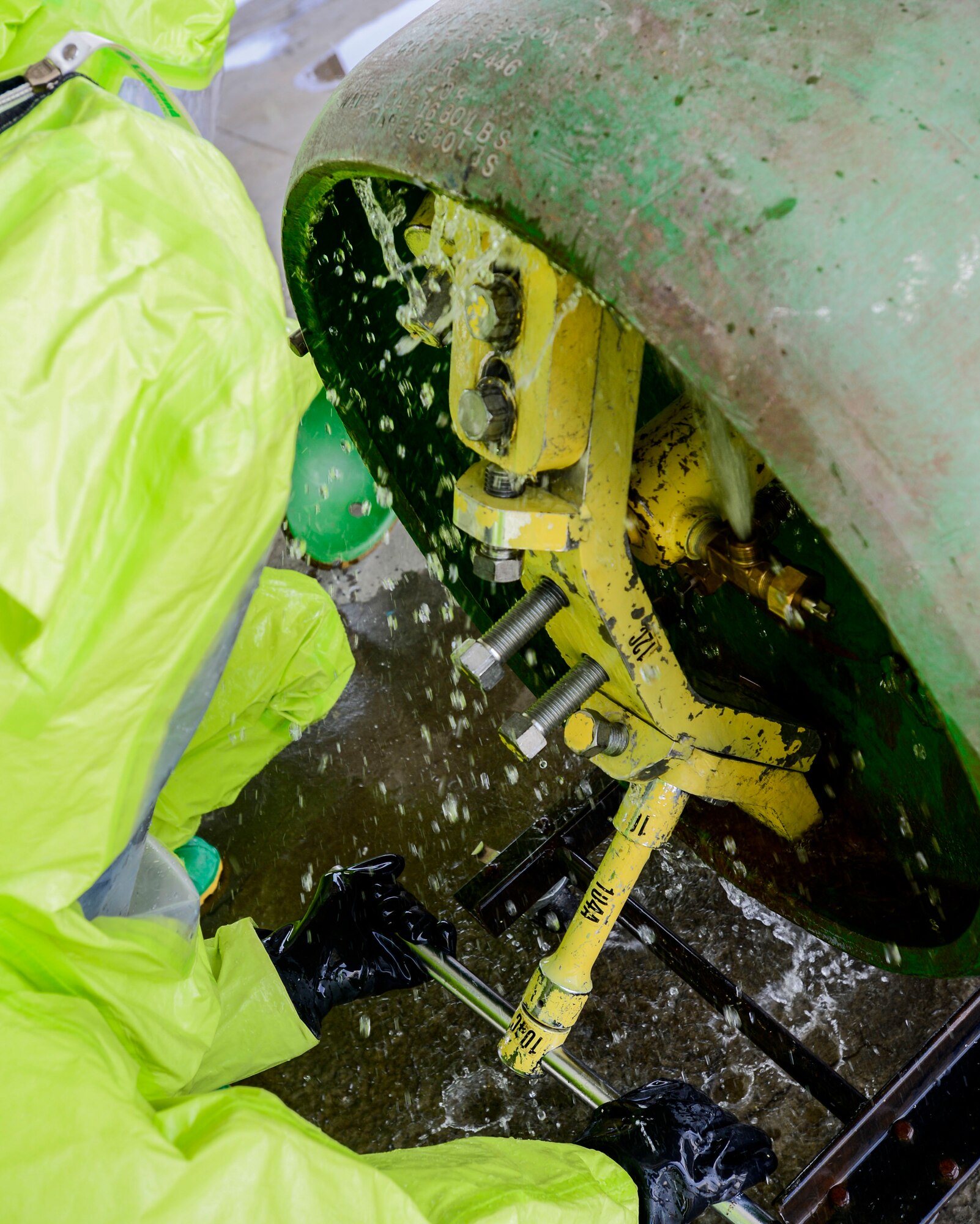 A firefighter of the 386th Civil Engineer Squadron tightens clamps to stop a simulated chlorine spill during hazardous material certification training at an undisclosed location in Southwest Asia, Sept. 26, 2015. Firefighters assist emergency response resources with fuel spills, oil spills and any other incident where there is a known or unknown hazardous substance. (U.S. Air Force photo by Senior Airman Racheal E. Watson/Released) 