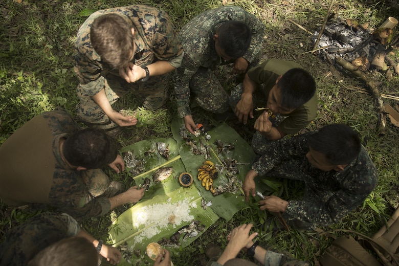 Philippine and U.S. Marines share a meal together during jungle survival training at Ternate, Philippines, Sept. 29, 2015 as part of Amphibious Landing Exercise 2015. The Marines learned basic jungle survival skills, such as building a fire, finding sources of fresh water and catching food. The Philippine Marines taught the U.S. Marines how to use the surrounding environment to self-sustain themselves in the jungle. PHIBLEX 15 is an annual, bilateral training exercise conducted by U.S. Marine and Navy Forces with the Armed Forces of the Philippines in order to strengthen our interoperability and working relationships across a wide range of military operations — from disaster relief to complex expeditionary operations. The Philippine Marines are reconnaissance men with 64th Force Recon Company, Marine Special Operations Group. The U.S. Marines are reconnaissance men with 3rd Recon Battalion, 3rd Marine Division, III Marine Expeditionary Force. 