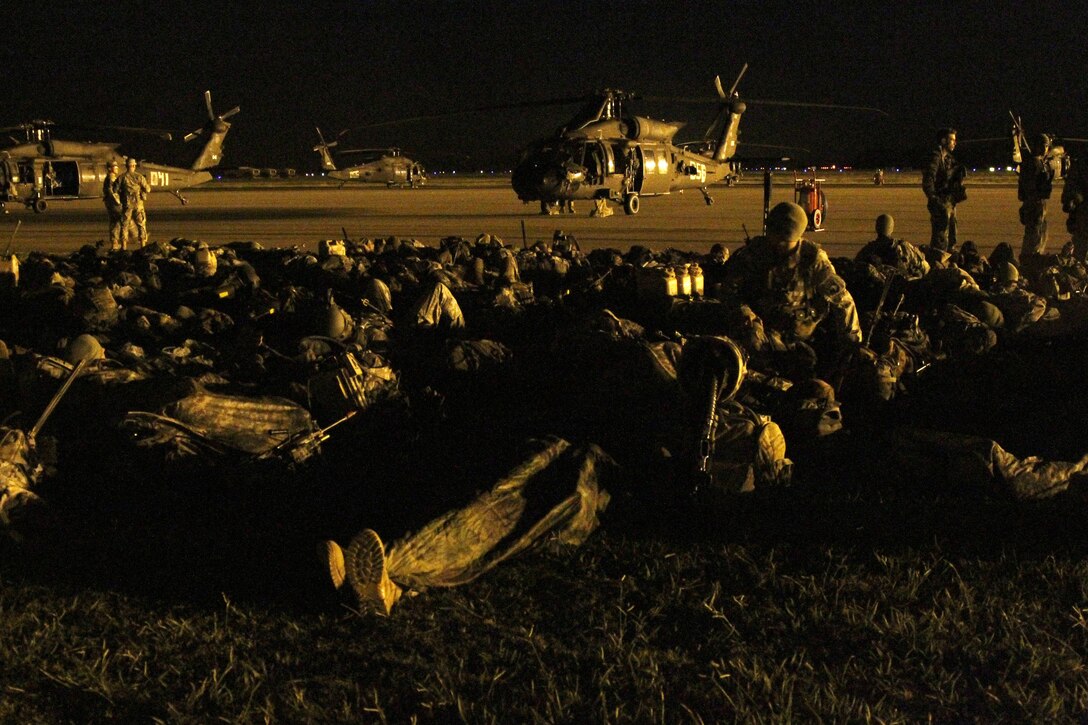 Paratroopers rest before they board their designated aircraft to conduct an air assault training mission at the Joint Readiness Training Center in Alexandria, La., Oct. 2, 2015. U.S. Army photo by Sgt. 1st Class Mary Rose Mittlesteadt