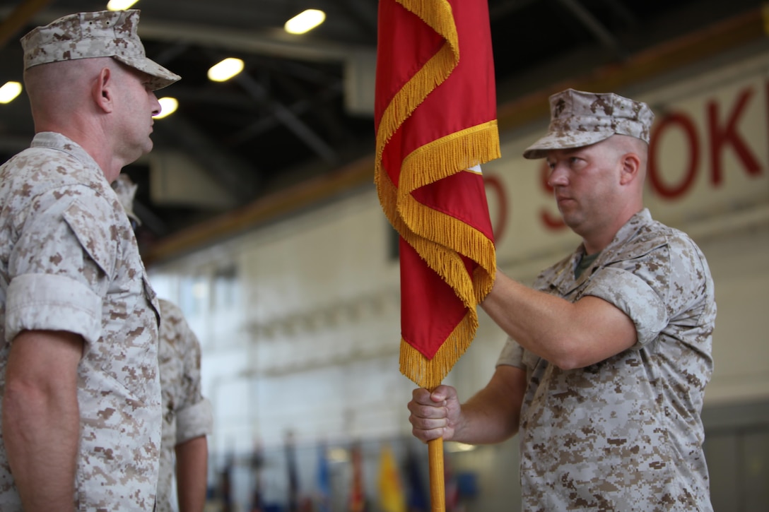 Lt. Col. Scott Koltick, (right), passes the flag to Lt. Col. Claiborne Rogers, (left), signifying the changing of command during an assumption of command ceremony for Marine Refueler Transport Squadron 252, at Marine Corps Air Station Cherry point, North Carolina, Oct. 1, 2015. (U.S. Marine Corps photo by Pfc. Nicholas P. Baird/ Released) 