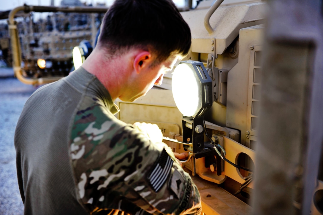 U.S. Army Sgt. Johnson adjusts the front lights as he prepares his vehicles, equipment, and weapons systems before a route clearance mission on Bagram Airfield, Afghanistan, Sept. 18, 2015. Johnson is assigned to the 101st Airborne Division’s Company A, 21st Engineer Battalion. U.S. Army Photo by Sgt. 1st Class David Wheeler