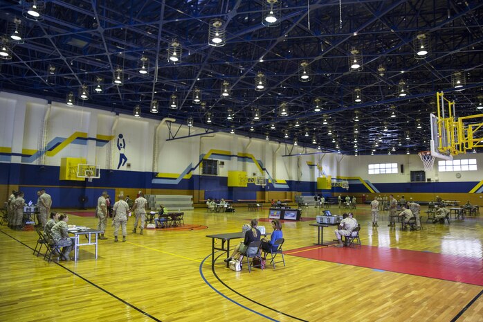 A variety of departments gathered together to conduct a noncombatant evacuation operation exercise inside the IronWorks Gymnasium at Marine Corps Air Station Iwakuni, Japan, Sept. 30, 2015. A NEO can be triggered by anything from a military threat to a natural disaster. This operation is conducted to evacuate noncombatants, nonessential military personnel, selected host-nation citizens, and third country nationals, who are in danger, to a safe location.