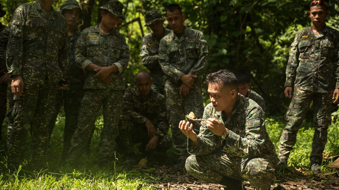 Philippine Marine Corps Staff Sgt. Bimbo R. Busico explains how to make a snare out of the surrounding environment during jungle survival training at Ternate, Philippines, Sept. 29, as part of Amphibious Landing Exercise 2015. The Marines learned basic jungle survival skills, such as building a fire, finding sources of fresh water and catching food. 