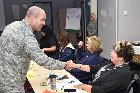 Chris Bullard, wife of Senior Master Sgt. Mike Bullard of the 910th Security Forces Squadron, receives a service coin from 910th Airlift Wing Commander Col. James Dignan here, Oct. 3, 2015. Chris Bullard attended the Key Spouse Program informational seminar given by the 910th Airman and Family Readiness Center. The program encourages a stronger sense of community through spouse-to-spouse support networks. (U.S. Air Force photo/Tech. Sgt. James Brock)