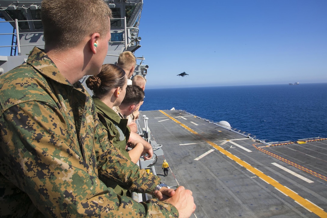 U.S. Marines watch from above as an AV-8B Harrier prepares to land during flight deck of the USS Boxer during Integration Training in the Pacific Ocean, Sept. 25, 2015. U.S. Marine Corps photo by Cpl. Briauna Birl