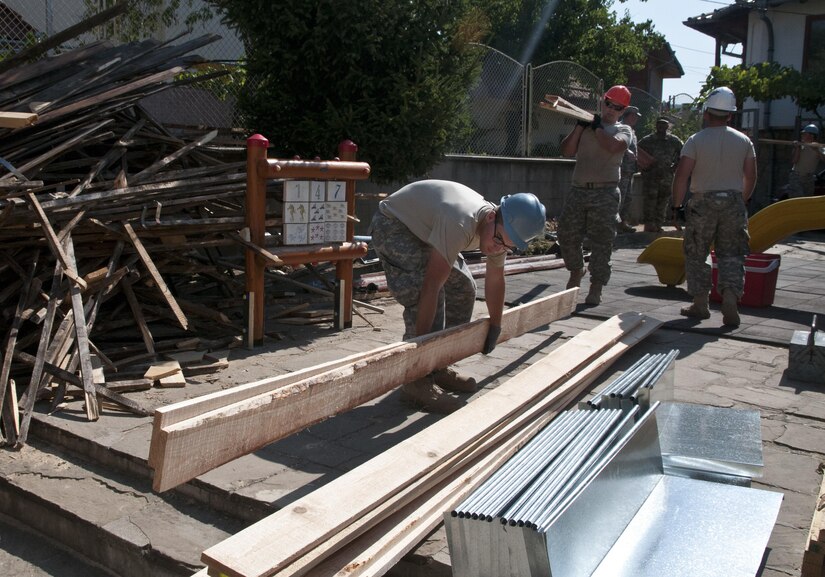 U.S. Army Reserve Spc. Christian Watts (front) stacks lumber while Spc. Jacob Nance brings another load. These construction engineer Soldiers with the 390th Engineer Company out of Chattanooga, Tenn., partnered with the Bulgarian Army to renovate a roof on Prolet Kindergarten in Veliko Tarnovo, Bulgaria, Aug. 3 to 19 for a Humanitarian Civil Assistance project funded by U.S. European Command through the U.S. Office of Defense Cooperation Bulgaria. (U.S. Army photo by Staff Sgt. Debralee Best)