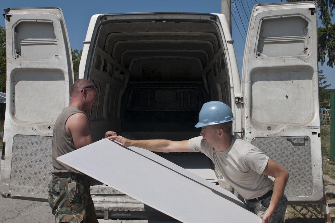 U.S. Army Reserve Pfc. Jared Poulson (right), construction engineer, 390th Engineer Company, loads drywall with Bulgarian Army Pvt. Borislav Borislavovileva. The 390th Engineer Company out of Chattanooga, Tenn., partnered with the Bulgarian Army to renovate two classrooms and a bathroom for the Tsersova Koria, Bulgaria kindergarten Aug. 3 to 19 for a Humanitarian Civil Assistance project funded by U.S. European Command through the U.S. Office of Defense Cooperation Bulgaria. (U.S. Army photo by Staff Sgt. Debralee Best)