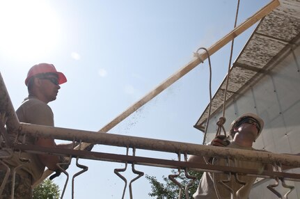 U.S. Army Reserve Spcs. Donald Stark (right) and Jacob Nance hoist lumber to the roof of Prolet Kindergarten in Veliko Tarnovo, Bulgaria. These construction engineer Soldiers with the 390th Engineer Company out of Chattanooga, Tenn., partnered with the Bulgarian Army to renovate the roof Aug. 3 to 19 for a Humanitarian Civil Assistance project funded by U.S. European Command through the U.S. Office of Defense Cooperation Bulgaria. (U.S. Army photo by Staff Sgt. Debralee Best)