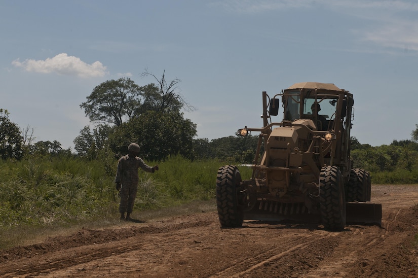 U.S. Army Reserve Sgt. Todd Hamiton directs Spc. Jordan Burke, both heavy equipment operators with the 712th Engineer Support  Company (Horizontal) out of York, S.C., while grading a road outside Fort Chaffee, Ark., Aug. 1 during Operation River Assault 2015. The unit provided road improvements to ensure vehicles had access to the river for the culminating event, the gap crossing. (U.S. Army photo by Staff Sgt. Debralee Best)