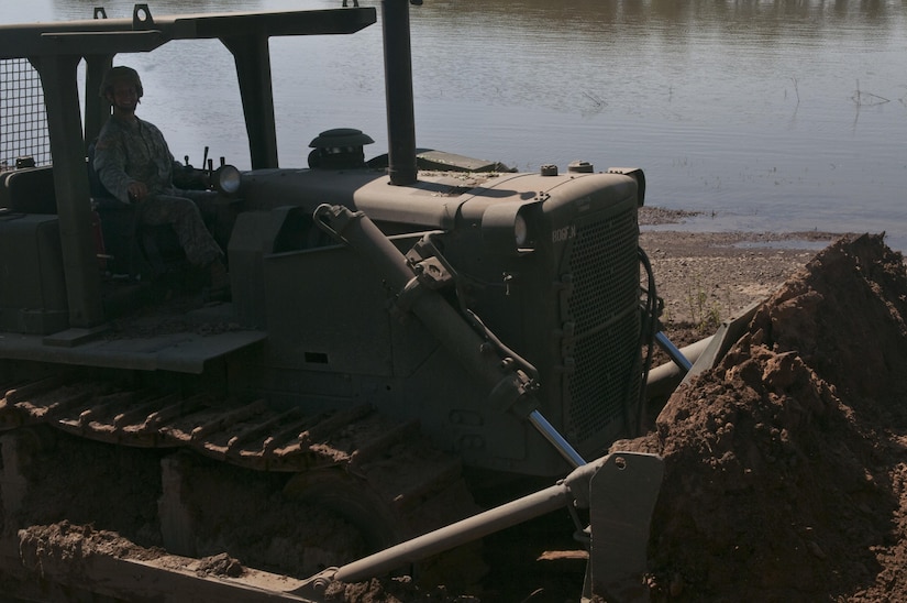 U.S. Army Reserve Sgt. Nicholas Chiodini, heavy equipment operator with the 712th Engineer Support Company (Horizontal) out of York, S.C., clears slip four of sediment at Fort Chaffee, Ark., Aug. 1 during Operation River Assault 2015. The unit cleared the slips of 2 to 4 inches of mud and debris to ensure vehicles had access to the river for the culminating event, the gap crossing. (U.S. Army photo by Staff Sgt. Debralee Best)