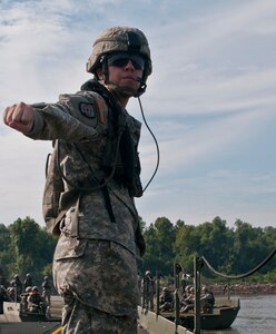 Sgt. Nicole Pierce, 401st Engineer Company, from Mustang, Okla., serves as the raft commander directing the watercraft to align both halves of an Improved Ribbon Bridge. Bridge crewmembers from different engineer companies joined forces deploying watercraft from transport trucks on the river bank, pushing bridge bays into place to construct the floating bridge across the Arkansas River, Aug. 4 as the culminating training event of Operation River Assault 2015 at Fort Chaffee, Ark.  (U.S. Army photo by Staff Sgt. Roger Ashley)