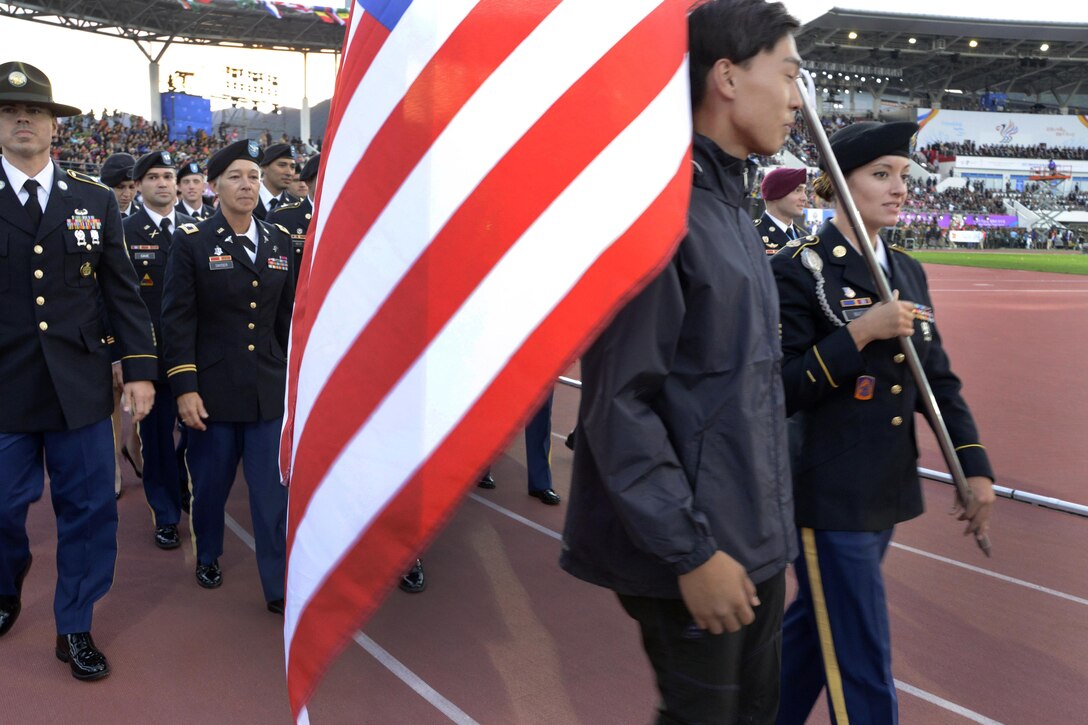 U.S. Army Sgt. Elizabeth Wasil carries the U.S. flag into the opening ceremony of the CISM World Games in Mungyeong, South Korea, Oct. 2, 2015. DoD photo by Gary Sheftick