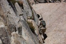 Lance Corporal Aron Garland, a radio operator assigned to Communications Company, Headquarters Battalion, 1st Marine Division, moves along a fixed lane during phase two of Mountain Warfare Training Exercise 5-15 aboard Marine Corps Mountain Warfare Training Center Bridgeport, Calif., Sept. 7, 2015. The training covered maneuvering throughout mountainous terrain features by rope climbing and rappelling as well as surviving in the rugged environment. (U.S. Marine Corps photo by Cpl. Will Perkins/Released)
