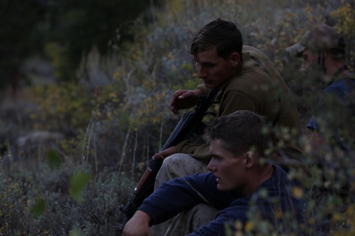 Corporal Darian Houston (top), a satellite communications operator and Cpl. Benjamin Stoflet (bottom), a field radio operator, both assigned to Communications Company, Headquarters Battalion, 1st Marine Division, observe their surroundings during phase three of Mountain Warfare Training Exercise 5-15 aboard Marine Corps Mountain Warfare Training Center Bridgeport, Calif., Sept. 21, 2015. Headquarters Battalion acted as the opposing force against 1st Battalion, 6th Marine Regiment, 2nd Marine Division for the field training exercise to give the Marines a realistic look at fighting in a mountainous terrain. (U.S. Marine Corps photo by Cpl. Will Perkins/Released)