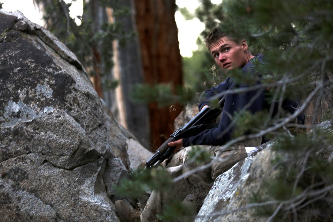 Corporal Benjamin Stoflet, a field radio operator, assigned to Communications Company, Headquarters Battalion, 1st Marine Division, watches for simulated enemy contacts during phase three of Mountain Warfare Training Exercise 5-15 aboard Marine Corps Mountain Warfare Training Center Bridgeport, Calif., Sept. 21, 2015. Headquarters Battalion acted as the opposing force against 1st Battalion, 6th Marine Regiment, 2nd Marine Division for the field training exercise to give the Marines a realistic look at fighting in a mountainous terrain. (U.S. Marine Corps photo by Cpl. Will Perkins/Released)