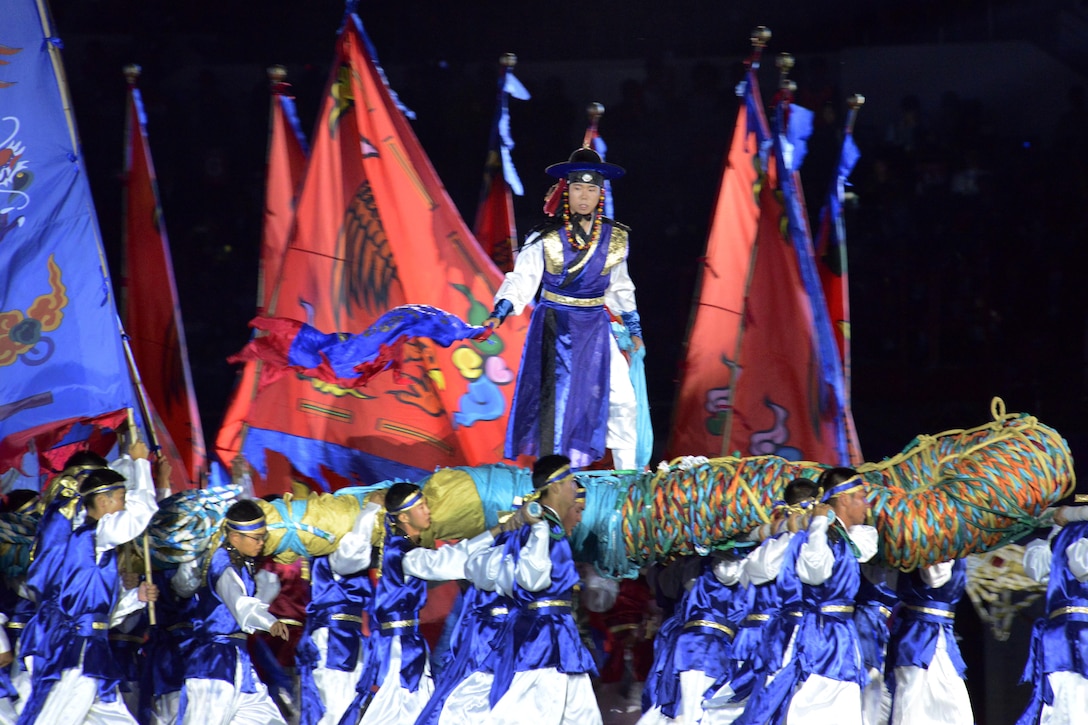 A scene of the 2015 6th Conseil International du Sport Militaire (CISM) World Games opening ceremony, depicts the traditional Korean game called Chajeon Nori in Mungyeong, South Korea, Oct. 2, 2015. It involves teams of men carrying large log frames called dongchae. Atop each dongchae is a commander who directs his team to maneuver against the opposing team.