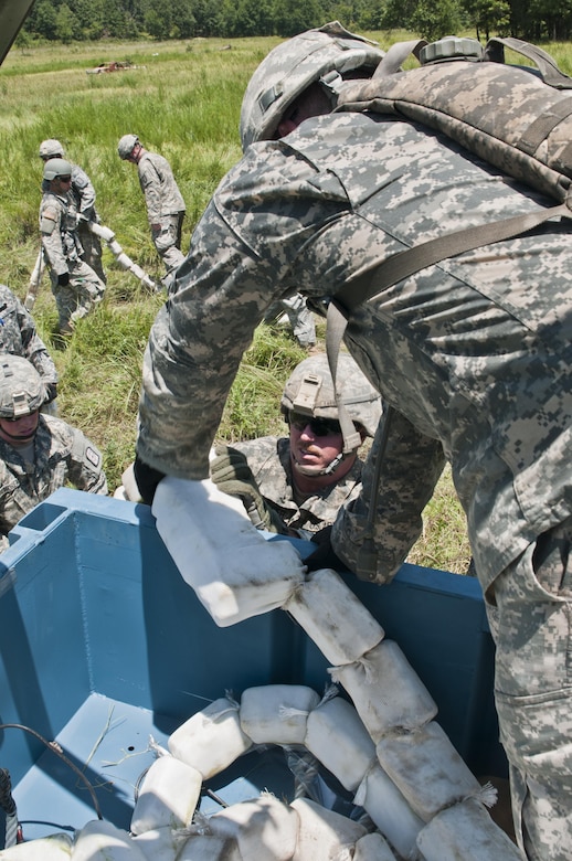 U.S. Army Reserve Soldiers with the 364th Engineer Company (Sapper) repack an inert C4 line to re-fire an M58 Mine Clearing Line Charge, rocket-projected line charge usually used to clear mines, during River Assault at Fort Chaffee, Ark., July 29. (U.S. Army photo by Staff Sgt. Roger Ashley)