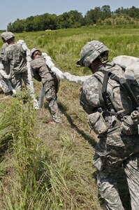 U.S. Army Reserve Soldiers with the 364th Engineer Company (Sapper) repack an inert C4 line to re-fire an M58 Mine Clearing Line Charge, rocket-projected line charge usually used to clear mines, during River Assault at Fort Chaffee, Ark., July 29. (U.S. Army photo by Staff Sgt. Roger Ashley)